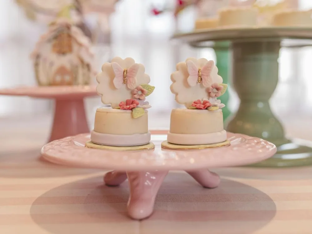 Mini bolos decorados com borboletas e flores de açúcar em boleira rosa