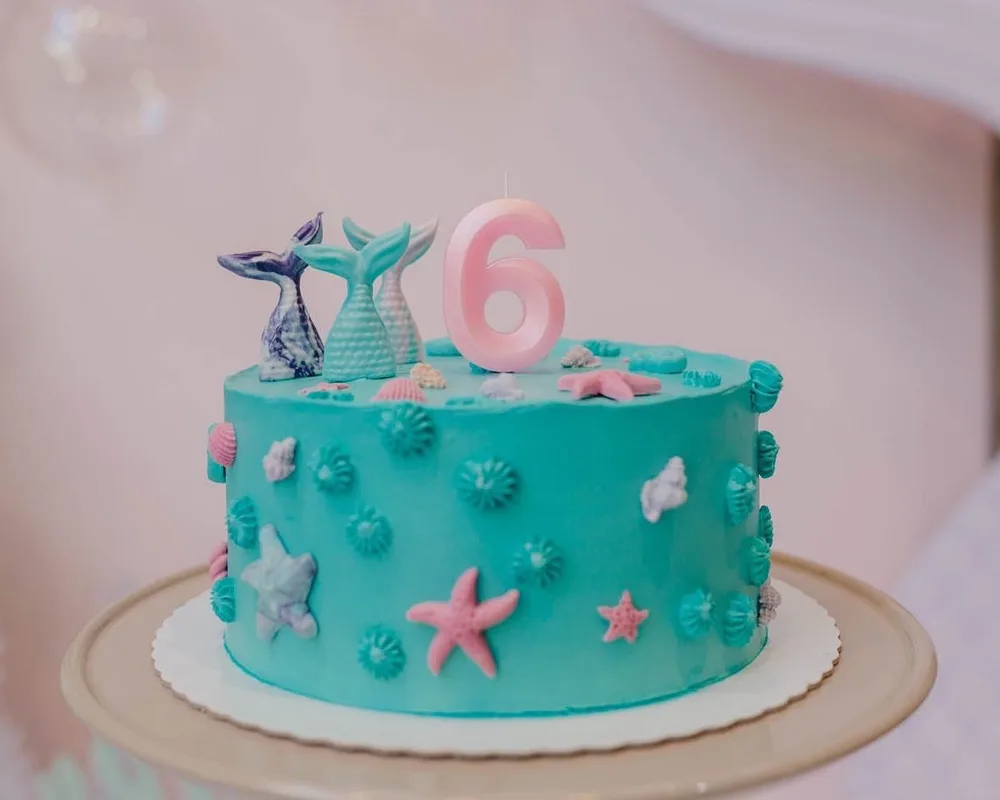 Bolo de aniversário tema sereia em tom turquesa com caudas modeladas e vela número seis